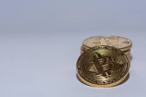 Stack of golden valueable bitcoins from crypto currency detail view with gray Stock Photos
