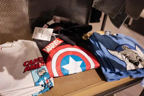 Stack of graphic tees featuring colorful superhero and cartoon designs on d.. Foto stock