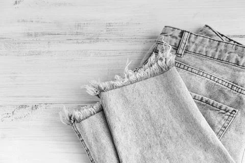 Stack of gray jeans on white background. Second hand clothing shop Stock Photos