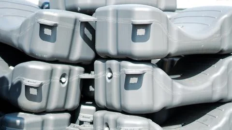 A stack of gray modular plastic floating dock sections in a harbor area. Stock Photos