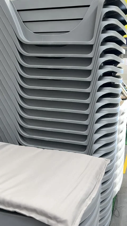 Stack of gray plastic sun loungers displayed for sale in a retail store Stock Footage 345173701