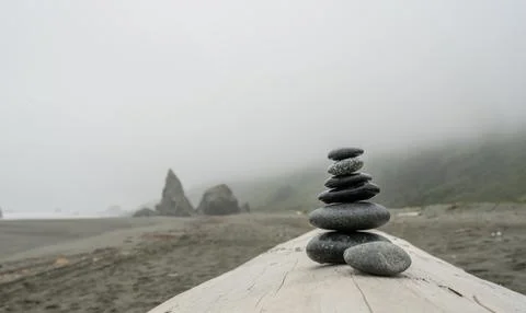 Stack of Gray Stones on Smooth Driftwood 库存照片