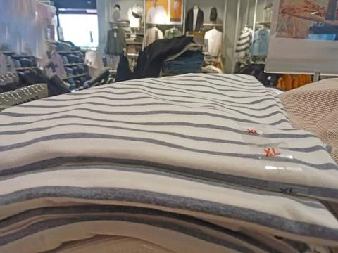 A stack of gray striped T-shirts is in a supermarket Stock Photos