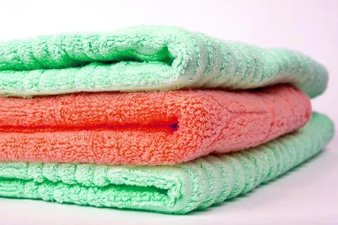 A stack of green and red terry towels folded in a stack Stock Photos