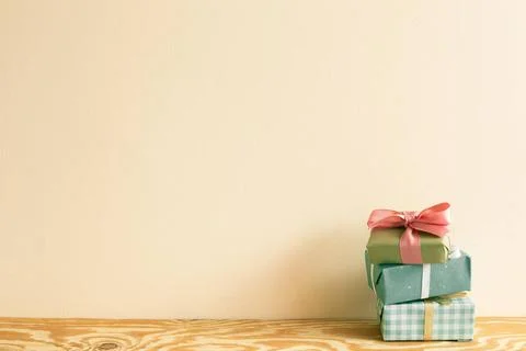 Stack of green gift boxes on wooden table. beige wall background Stack of ... 写真素材