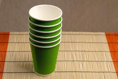A stack of green paper cups on a bamboo stand Stock Photos