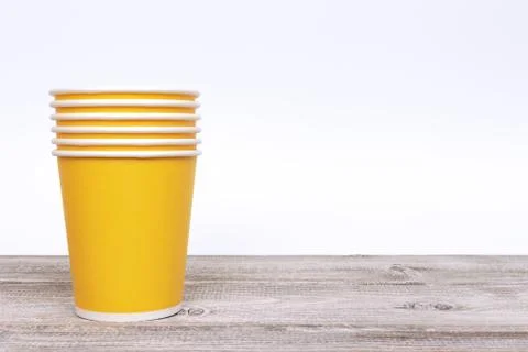 Stack of green paper disposable cups for coffee and nonalcoholic drinks on wo Stock Photos