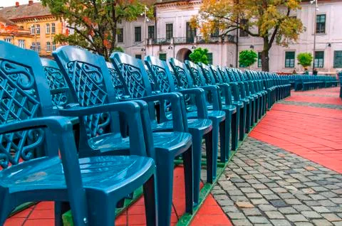 Stack of green plastic chair in the city square Stock Photos