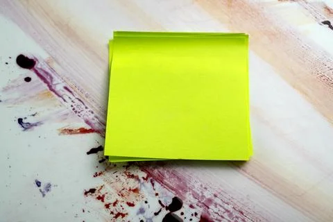 A stack of green sticky notes on a colorful red blood-splattered surface. H.. Stock Photos