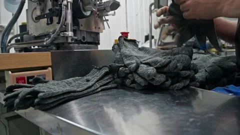 Stack of grey protective work gloves on metal workbench in textile manufacturing Stock Footage 344972066