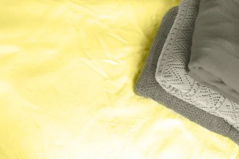 Stack of grey sweaters on yellow. Stock Photos