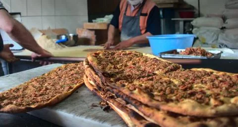 Stack of ground beef pitas put on marble ground with bakers on background wor Stock Photos