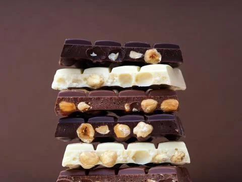 Stack of half chocolate bars with hazelnuts - milk chocolate, dark chocolat.. Stock Photos