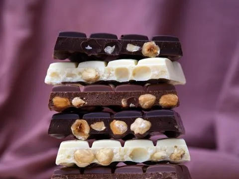 Stack of half chocolate bars with hazelnuts - milk chocolate, dark chocolat.. Stock Photos