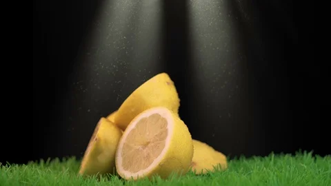 A stack of halves of lemons placed in the center of a grassy surface Stock Footage 111947452