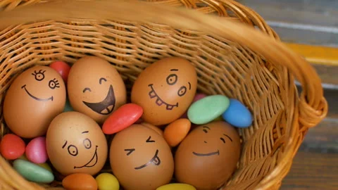 Stack of hand drawn smiley eggs on straw basket with colorful candy, easter Video stock 151164539