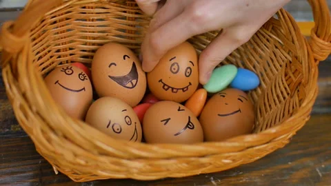 Stack of hand drawn smiley eggs on straw basket with colorful candy, easter Video stock 151246437