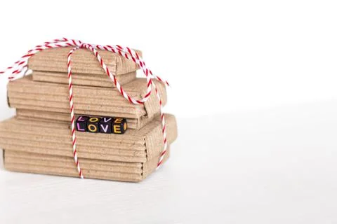 Stack of handcraft gift boxes on white wooden background with text Love of co Stock Photos