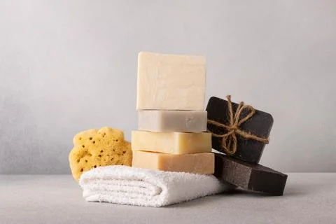 Stack of handcrafted soap bars, white terry towel and natural sea sponge. Nat Foto stock