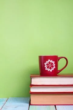 Stack of hardback books, diary on wooden deck table and green background. Back Stock-Fotos