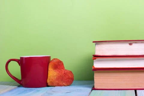 Stack of hardback books, diary on wooden deck table and green background. Back Foto stock