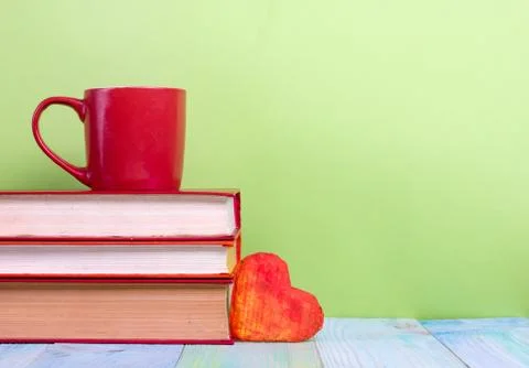 Stack of hardback books, diary on wooden deck table and green background. Back Stock Photos
