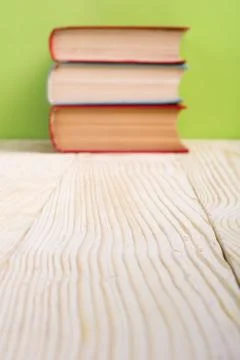 Stack of hardback books, diary on wooden deck table and green background. Back 스톡 사진