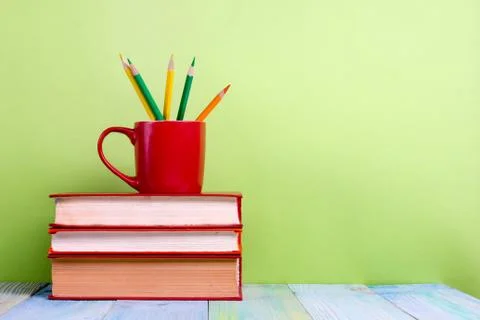 Stack of hardback books, diary on wooden deck table and green background. Back Stock-Fotos