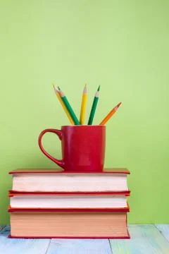 Stack of hardback books, diary on wooden deck table and green background. Back Stock-Fotos
