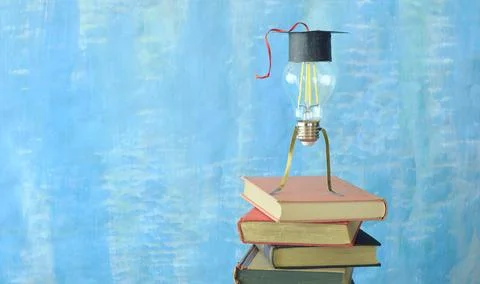 Stack of hardback books with graduation hat and lightbulb,education Stock Photos