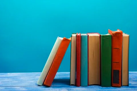 Stack of hardback books on wooden table. Back to school. Copy space for text Photos