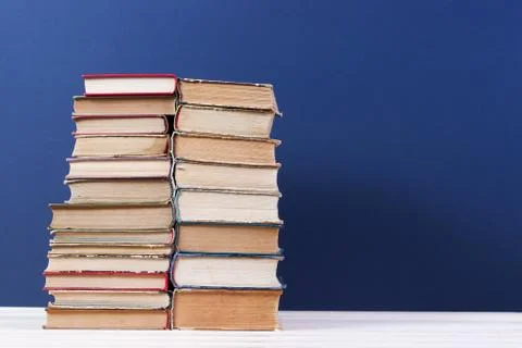 Stack of hardback books on wooden table Stock Photos