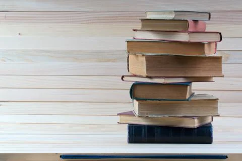 Stack of hardback books on wooden table. Back to school. Stock Photos