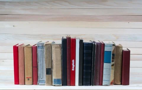 Stack of hardback books on wooden table. English textbook. Stock Photos