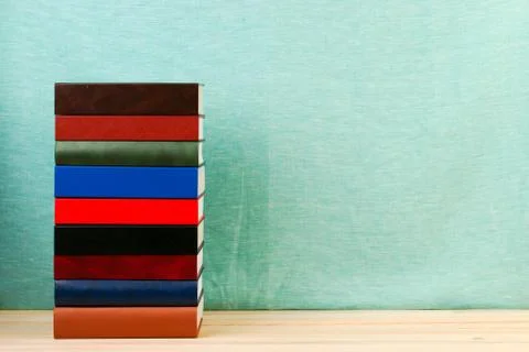 Stack of hardback books on wooden table Stock Photos