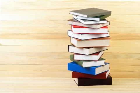 Stack of hardback books on wooden table Stock Photos
