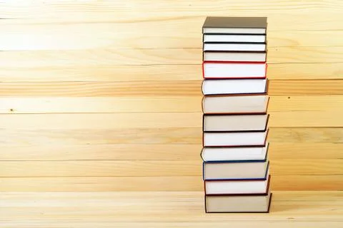 Stack of hardback books on wooden table Stock Photos