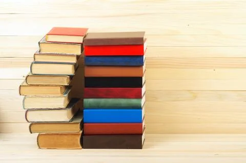 Stack of hardback books on wooden table Stock Photos