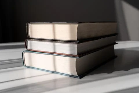 Stack of Hardcover Books with Light and Shadow on White Background for Educ.. Stock Photos
