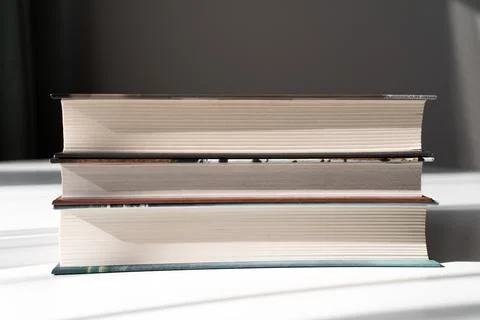 Stack of Hardcover Books with Light and Shadow on White Background for Educ.. Stock Photos