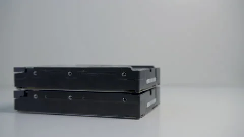 A stack of HDD disks on a white table. 4K stock footage. Stock Footage 155320482
