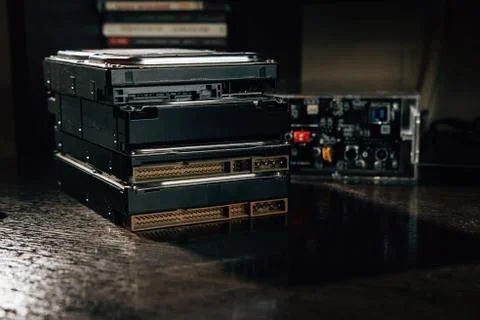 The stack of HDDs on the office table with case for HDD at the background Stock Photos