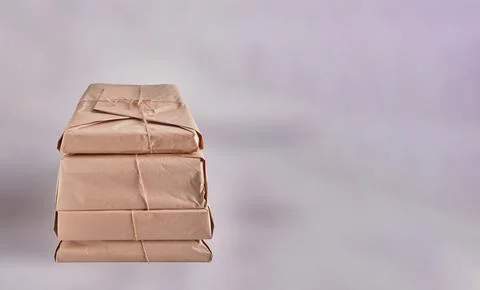 A stack of heavy parcels wrapped in kraft paper and tied with natural jute .. Stock Photos