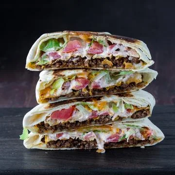 A stack of homemade crunch wraps against a dark background. Stockfoto's