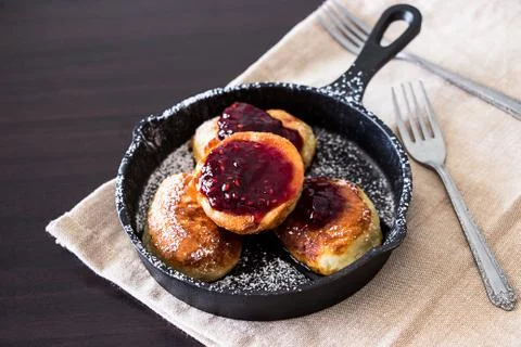 Stack of homemade fried Pancakes with Raspberry jam in small cast-iron frying Stock Photos