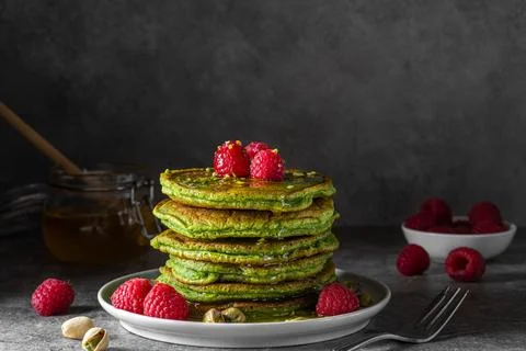 Stack of homemade pancakes with matcha tea, fresh raspberries, pistachios a.. Stock Photos