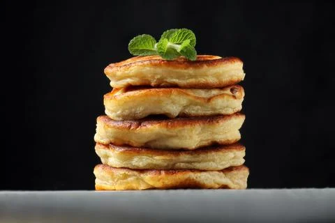 Stack of homemade pancakes with mint on a black background Stock-Fotos