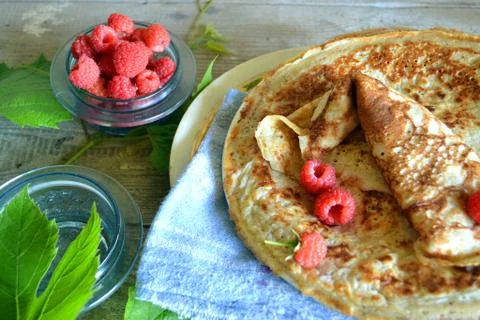 Stack of homemade thin pancakes or crepes, fresh raspberry, traditional russi Stock Photos