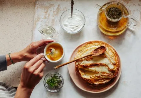 Stack of hot classic Russian thin pancakes. Rustic style. Sour cream, butter Stock Photos