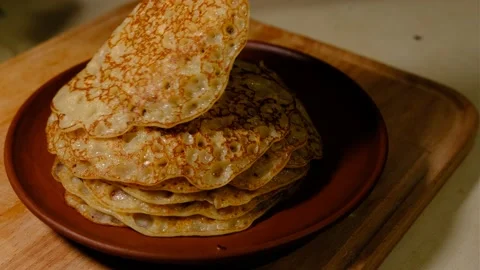 A stack of hot pancakes. Man put pancake on top. Pancakes with holes. Pancake we 스톡 동영상 168543414